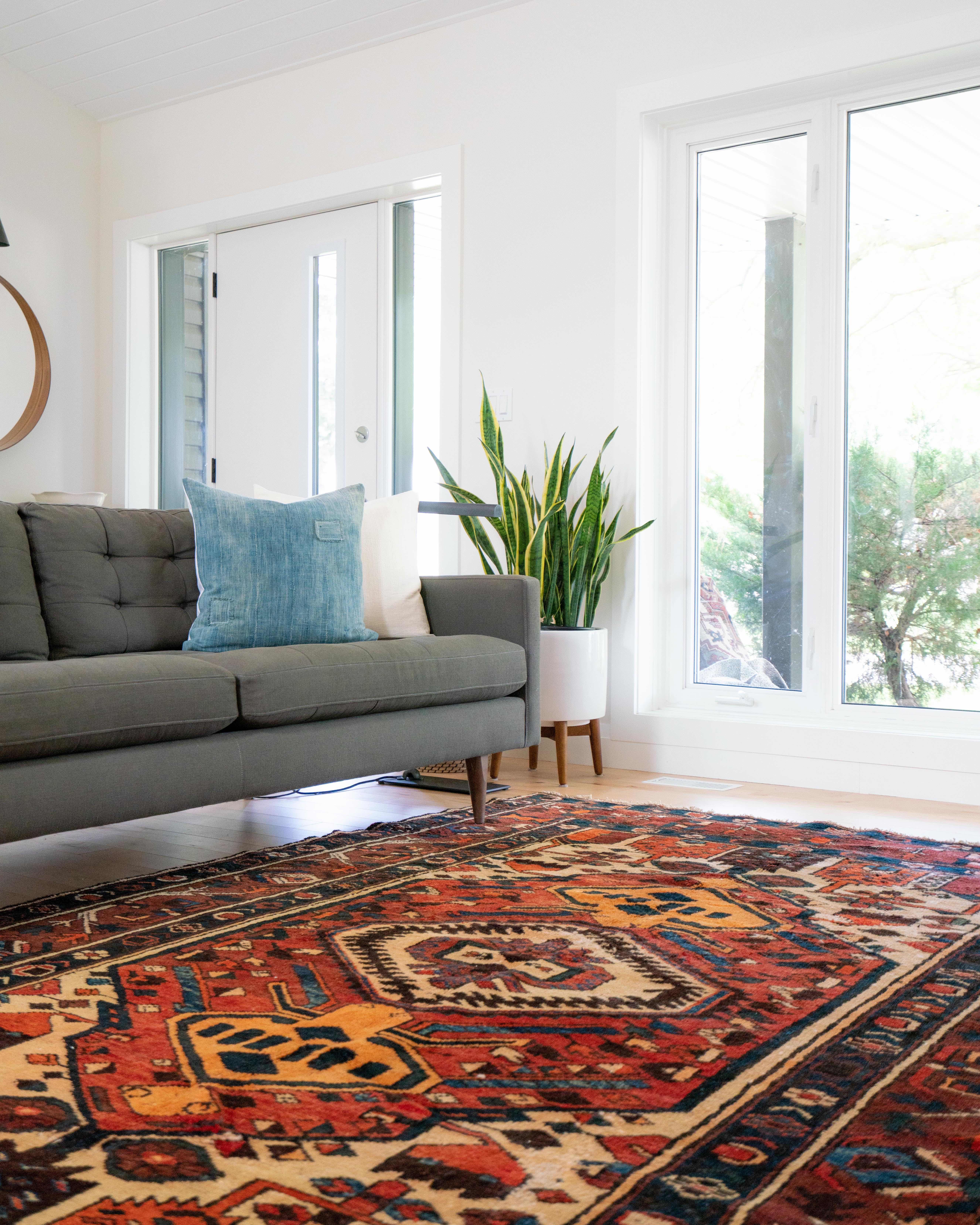 Bright home with modern couch and colorful rug.