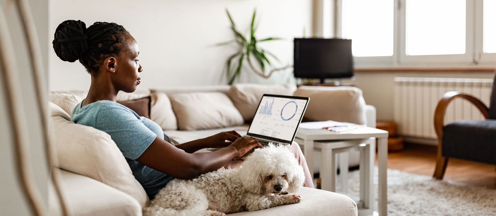 Woman with laptop on couch. How Much House Can I Afford in a Sellers’ Market?