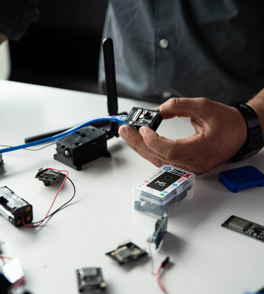 Assorted circuits, small cameras, and scanners laid across a table to be tested in a Lowe's Home Improvement store.